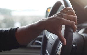 A hand at the wheel, driving