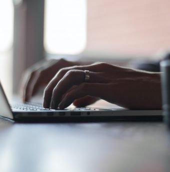 A person typing at their laptop